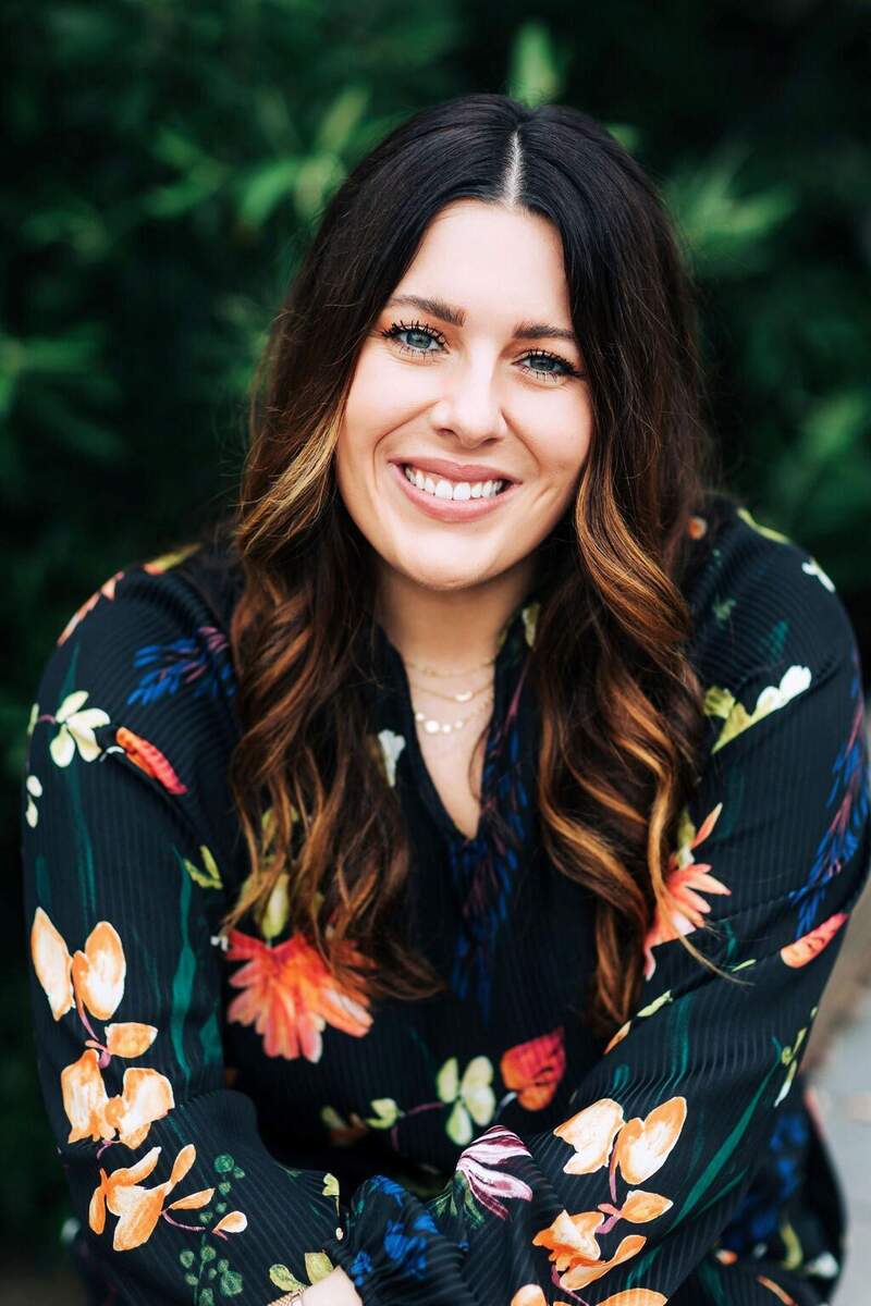Courtney Reid, woman with long dark hair wearing black bouse with floral pattern