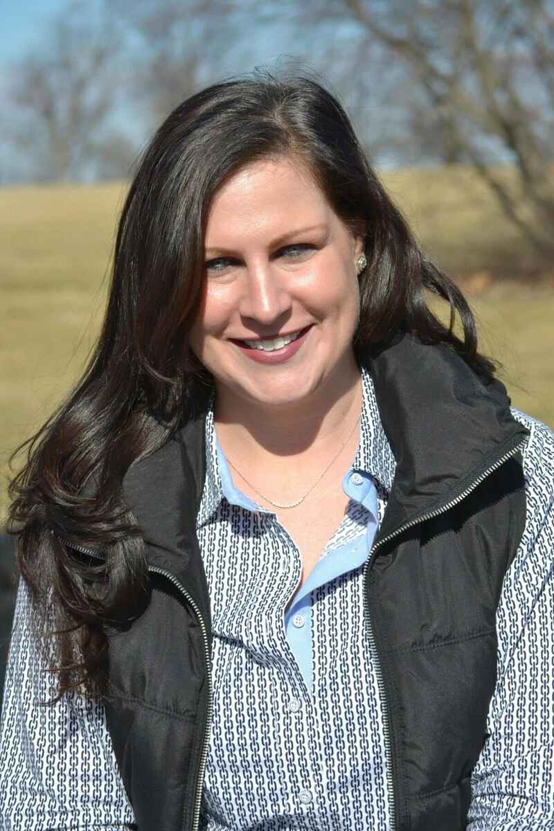 Jenn Roytz, woman with long dark hair, wearing patterned shirt and black vest